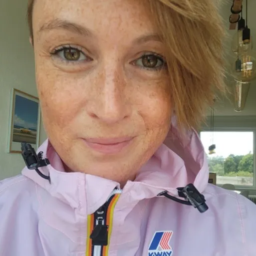 a woman from upclose smiling and looking into the camera