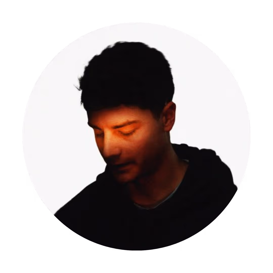 a profile picture of a guy with a red orangey light stroking his face